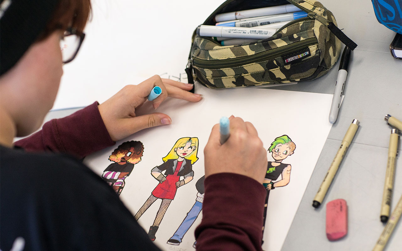 Teen student drawing a comic illustration.