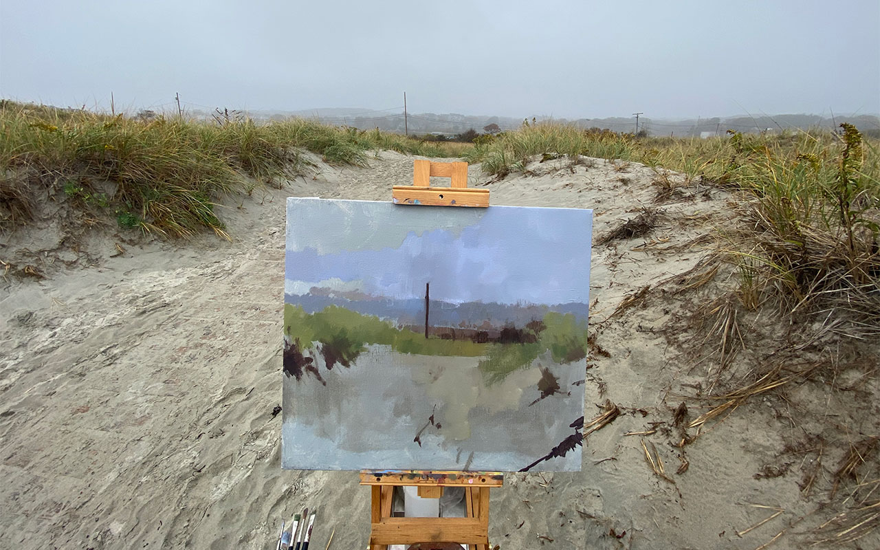 painting easel and canvas set up among beach dunes.