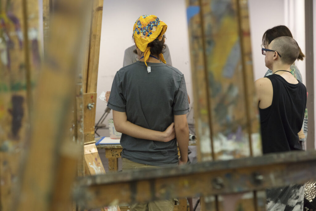 A student draws a large-scale portrait.