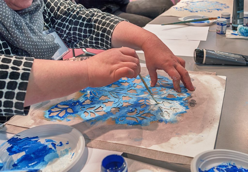 student painting a stenciled pattern