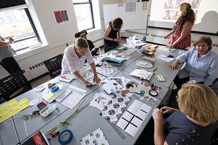 students working around a table of art supplies and patterns