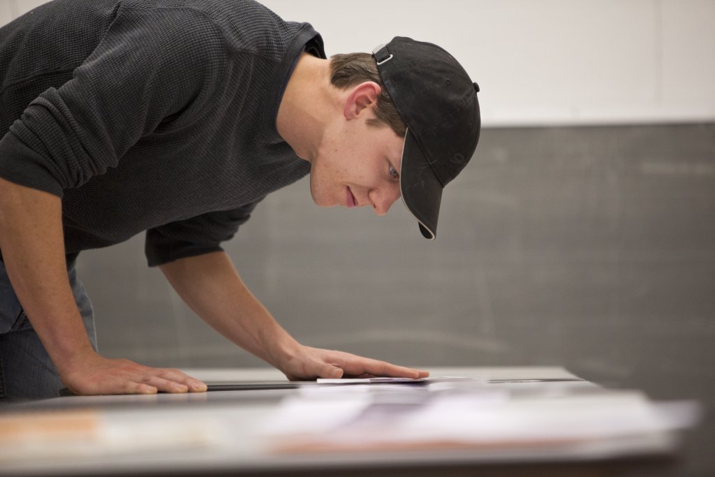 20101202_RISD_165 person leaning over table looking at papers