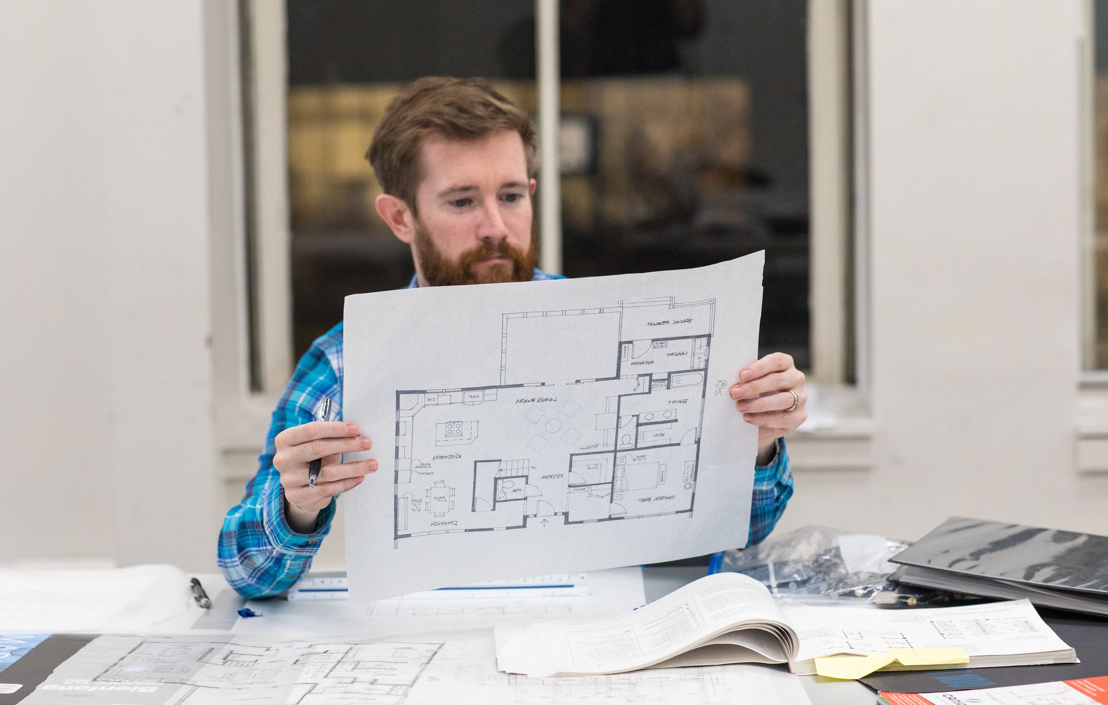RISD CE student holding up a draft of a building design plan.