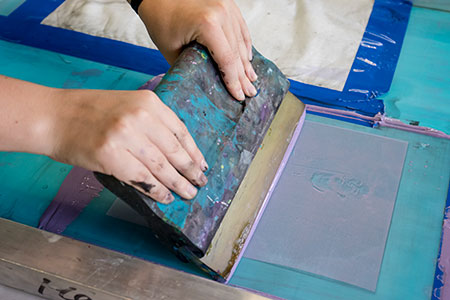 student painting a stenciled pattern