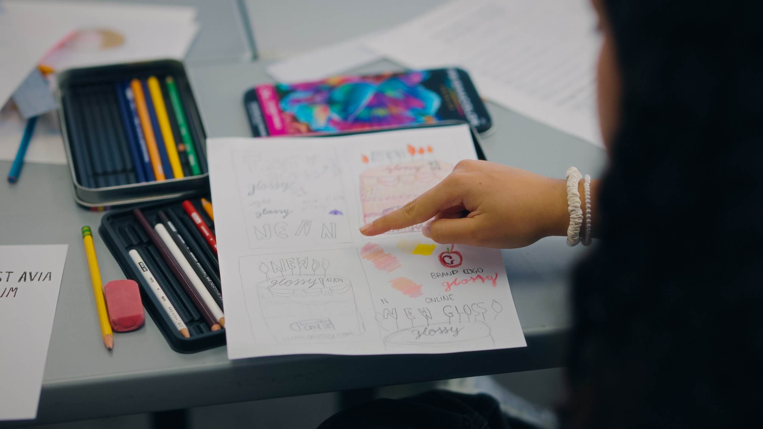 Art and design student working on a branding project using colored pencils. Teens experience real-world creative projects this fall at RISD with Instructor Michelle Perez.
